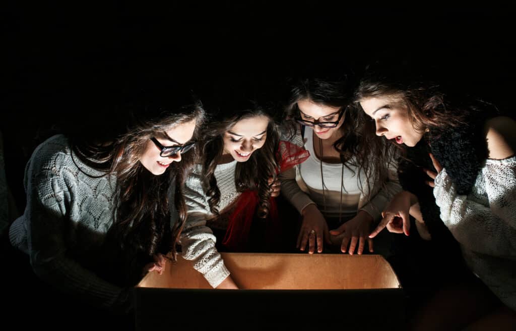 Sisters opens a box with a Christmas present and fascinated look